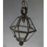 A bronzed hexagonal hall lantern with glazed panels, the central collar with open spiral ribbon,