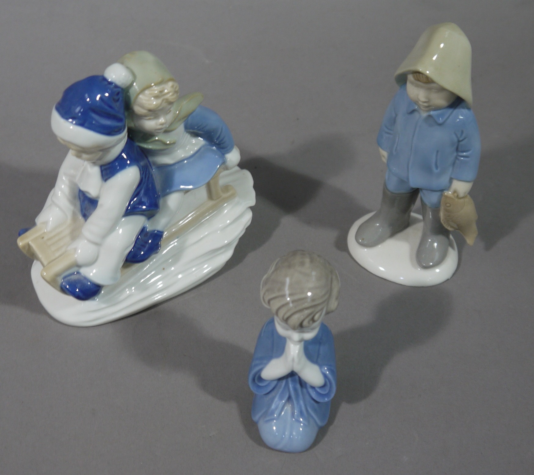 A continental pottery figure of children on a sledge,