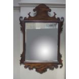 A 19th century mahogany mirror of 18th century design having a fret work frame and rectangular