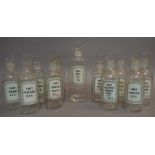 A set of ten clear glass pharmacy bottles 14cm high and one 16cm high,