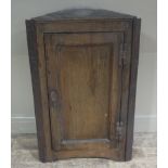 An early George III oak hanging corner cupboard with rectangular hanging panelled door,