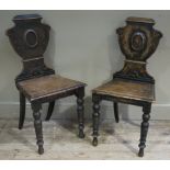A pair of 19th century oak hall chairs each having an urnular back and on turned legs