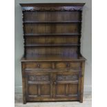 A 19th century style oak dresser and rack having a moulded cornice above a cut apron,