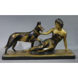 An Art Deco style plaster figure group of a recumbent woman with Alsatian, gold and black decorated,