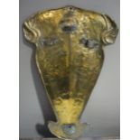 A brass sword shield of shaped outline,