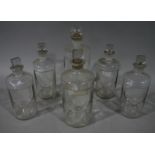 A set of five clear glass pharmacy bottles,