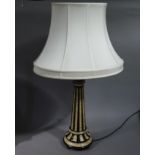 A resin lamp of tapered cylindrical form on spreading circular base, topped with a sphere finial,