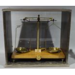 A set of large brass laboratory scales by W B Nicholson of Glasgow mounted on a wooden base and in