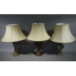 Three decorative table lamps one with foliate decoration another verdigris and a stained wooden