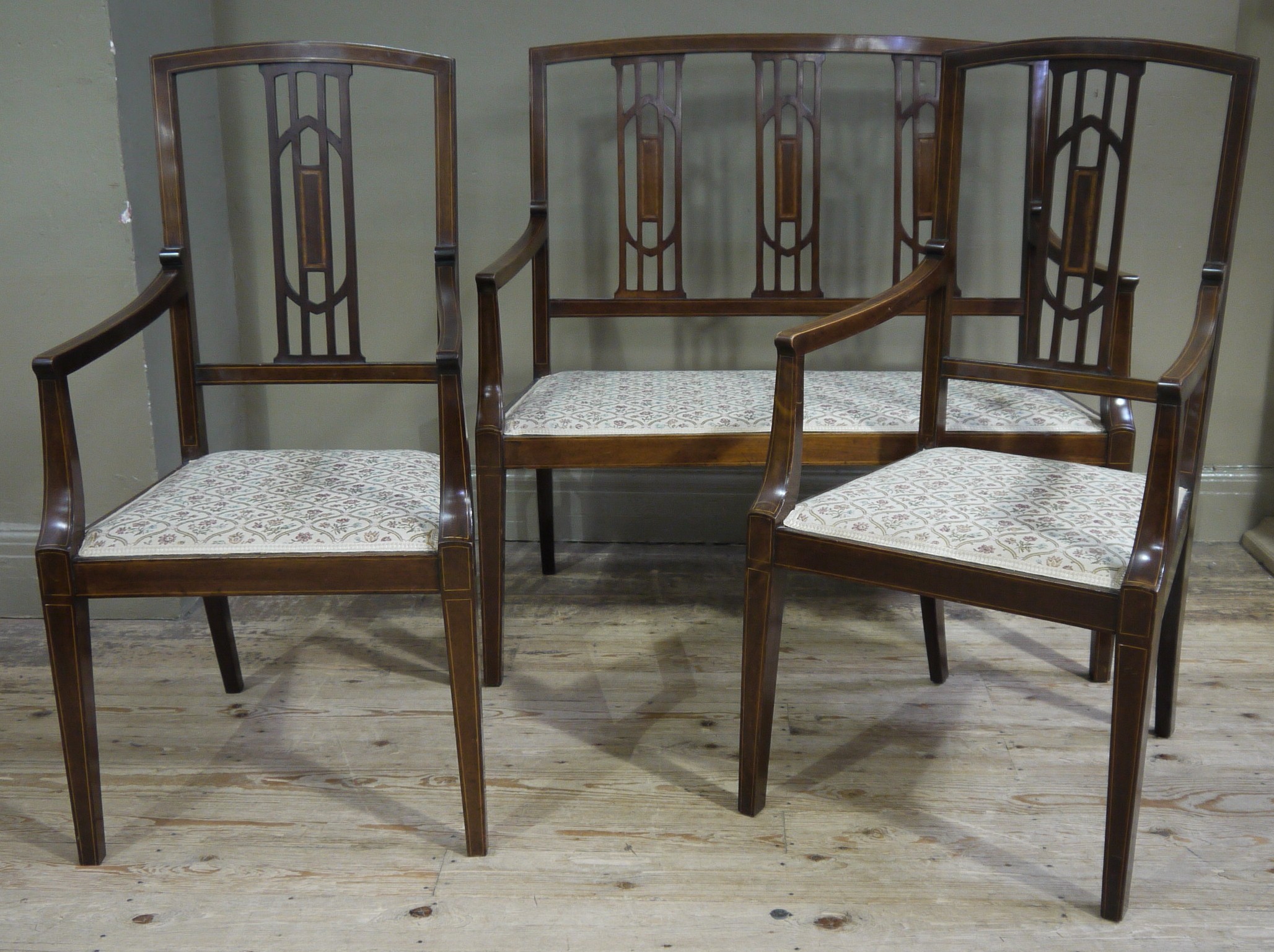 An Edwardian mahogany occasional settee and pair of chairs having pierced vertical splats