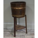 An oak and copper bound plant stand on three square legs joined by a triangular undertier by Lister
