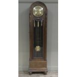 A 1930s oak longcase clock of arched profile having a circular brass dial with black Arabic