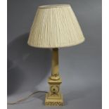 A metal table lamp decorated with floral trails and circlets with pleated cream shade