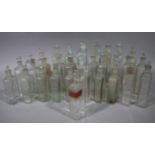 A set of 32 clear glass pharmacy flask bottles with stoppers, various sizes,