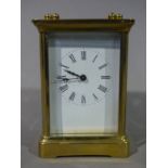 A brass cased carriage clock the white dial with Roman numerals, 12cm high,
