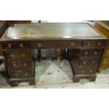 A mahogany kneehole desk having a leather incised writing surface above three drawers across and