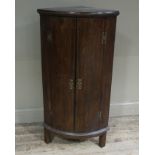 A George III mahogany hanging corner cupboard enclosed by a pair of doors, each barber pole strung,