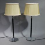 A pair of modern ebonised wooden and chromium plated table lamps with pleated pale silk shades,