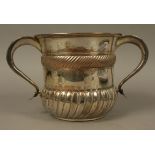 An 18th century Sheffield plate two handled cup of cylindrical form with lobed and fluted bellied