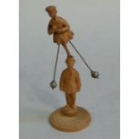 An interesting carved softwood balancing figure the upper female figure with skirt and pair of lead