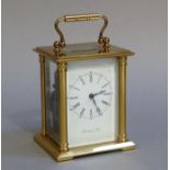 Richard & Cie - a brass cased carriage clock with swing handle the white dial with Roman and Arabic