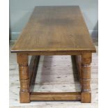 A reproduction oak refectory table in late 17th century style the cleated top above a frieze