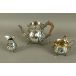 A Victorian three piece silver tea service of spiral fluted cauldron form with shaped everted lip,