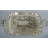 A two handled shaped rectangular tray in George III style the field engraved with C-scrolls and