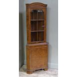 A reproduction burr walnut veneered standing corner cupboard in George II style with cavetto