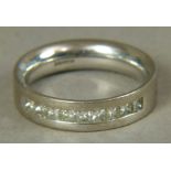 A diamond set band in 18ct white gold the princess cut stones channel set in line,