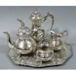 A four piece silver plated tea service together with a silver plated shaped circular tray with cast