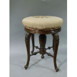 An Edwardian mahogany circular revolving piano stool the stuffed over top upholstered in floral