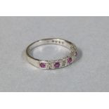 A ruby and diamond half hoop eternity ring in 9ct white gold,