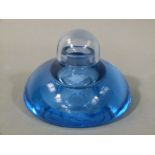 A pale blue glass inkwell of compressed sack form with shallow well and domed loose cover,