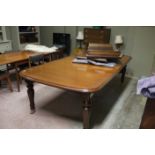 A reproduction mahogany extending dining table in Victorian style,