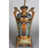 A late 19th century ormolu and champleve enamelled lamp, of vase shape,