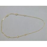 A neckchain in 9ct gold of box link, oval striated and polished spherical beads,