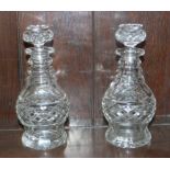 A pair of cut glass decanters with thistle shaped stoppers, cut triple ring necks and cut bodies,
