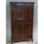 A reproduction mahogany George III style wardrobe with dentil moulded cornice and pair of figured