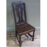 A Queen Ann style oak hall chair boldly carved overall with vasular splat bordered seat and gouge