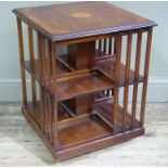 A reproduction mahogany revolving bookcase in Edwardian style the figured top centred on a shaded