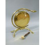 A Victorian brass dinner gong, the scrolling branch frame hanging the circular gong,