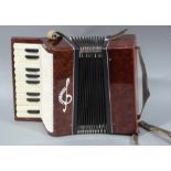 An accordion with simulated red stained plastic ends, paper bellows,