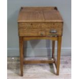 A late Victorian oak slope front shop desk fitted with till drawer with three quarter gallery and