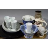 A set of six white pottery goblets, a Denby shell moulded dish, a circular black platter,