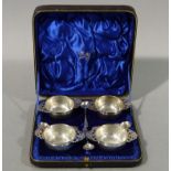 A set of four silver salts and four accompanying spoons,
