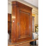 A George III oak hanging corner cupboard with flared cornice, figured mahogany frieze,