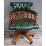 A reproduction swivel captain's chair upholstered in buttoned green leather