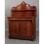 A Victorian mahogany chiffonier, the arched raised back with carved leaf cresting above a shelf,