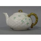 A Belleek basket weave compressed globular teapot decorated with clover leaves,